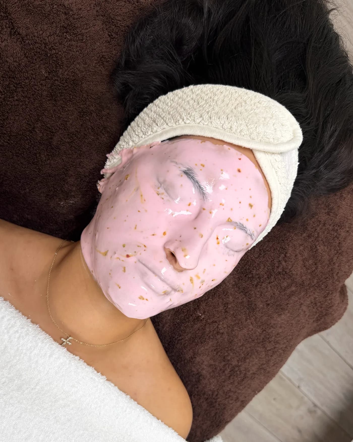 A pink jelly mask with golden flakes on the face, seen from above