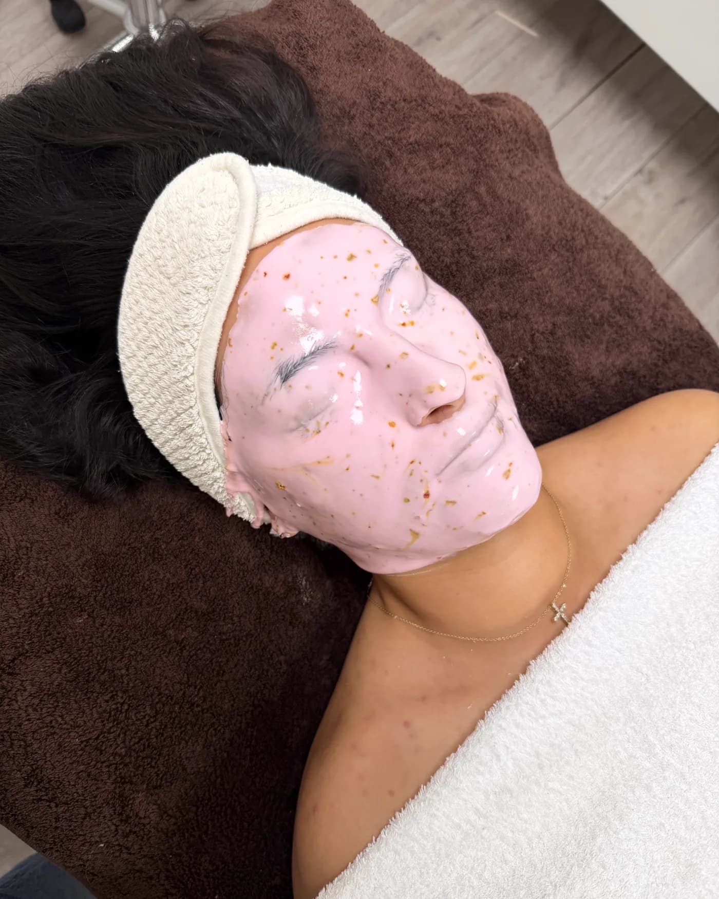 Eine rosa Jelly-Maske mit goldenen Flocken auf dem Gesicht