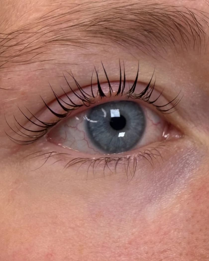 Hetzelfde oog na een lash lift en verven, met donkere, gekrulde wimpers