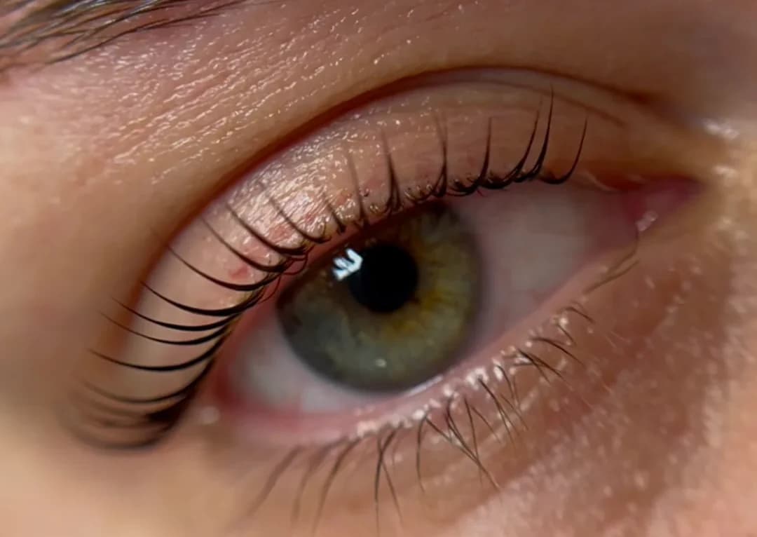 Ein Auge aus der Nähe mit dunklen Wimpern, die nach oben stehen